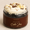 A gourmet chocolate cake jar by Avenue 42, featuring a dark chocolate cake base, piped white cream on top with chocolate curls and shavings, and a brown label with cream lettering.